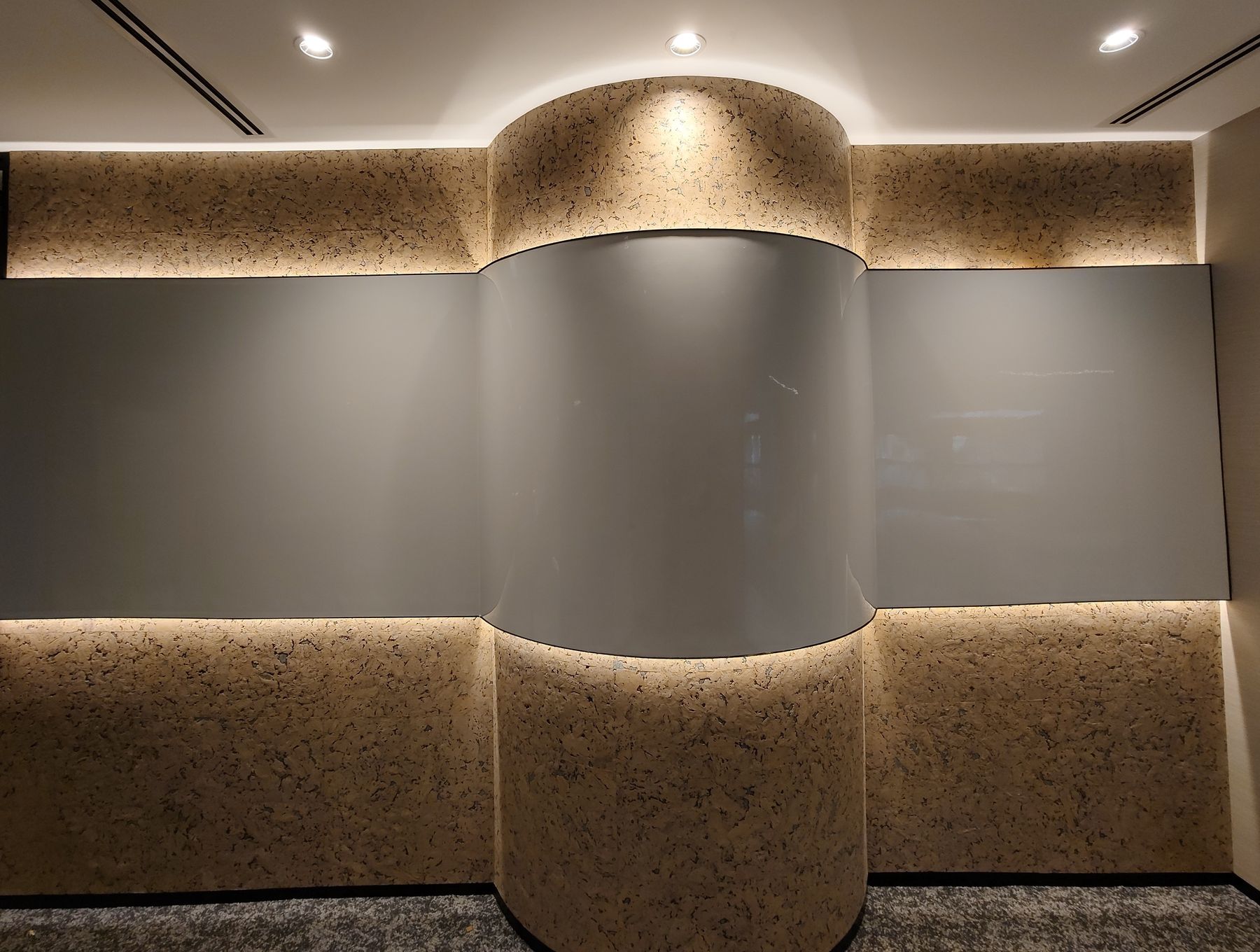 Curved writable wall with Wryte film, wood panelling and warm cove lighting