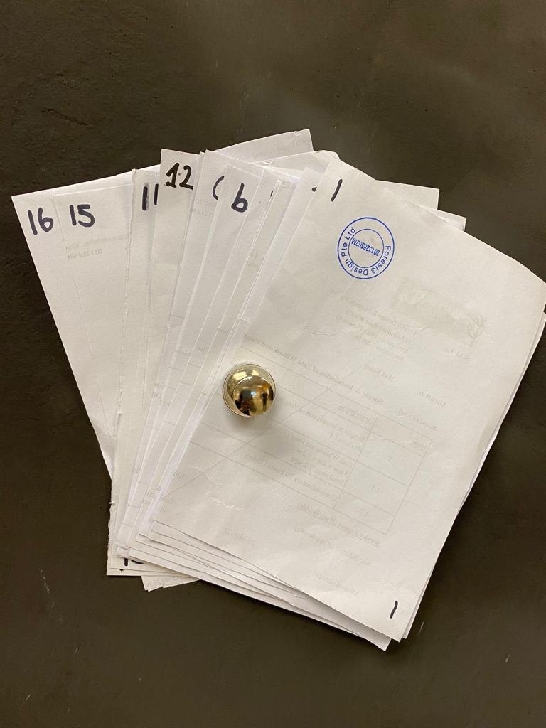A stack of papers held on a magnetic plaster wall by one neodymium magnet during a holding test