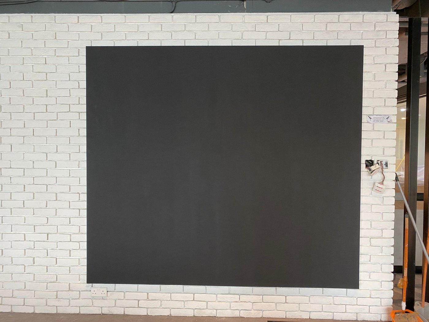ZETA Magnetic Plaster panel applied on a white brick-effect wall