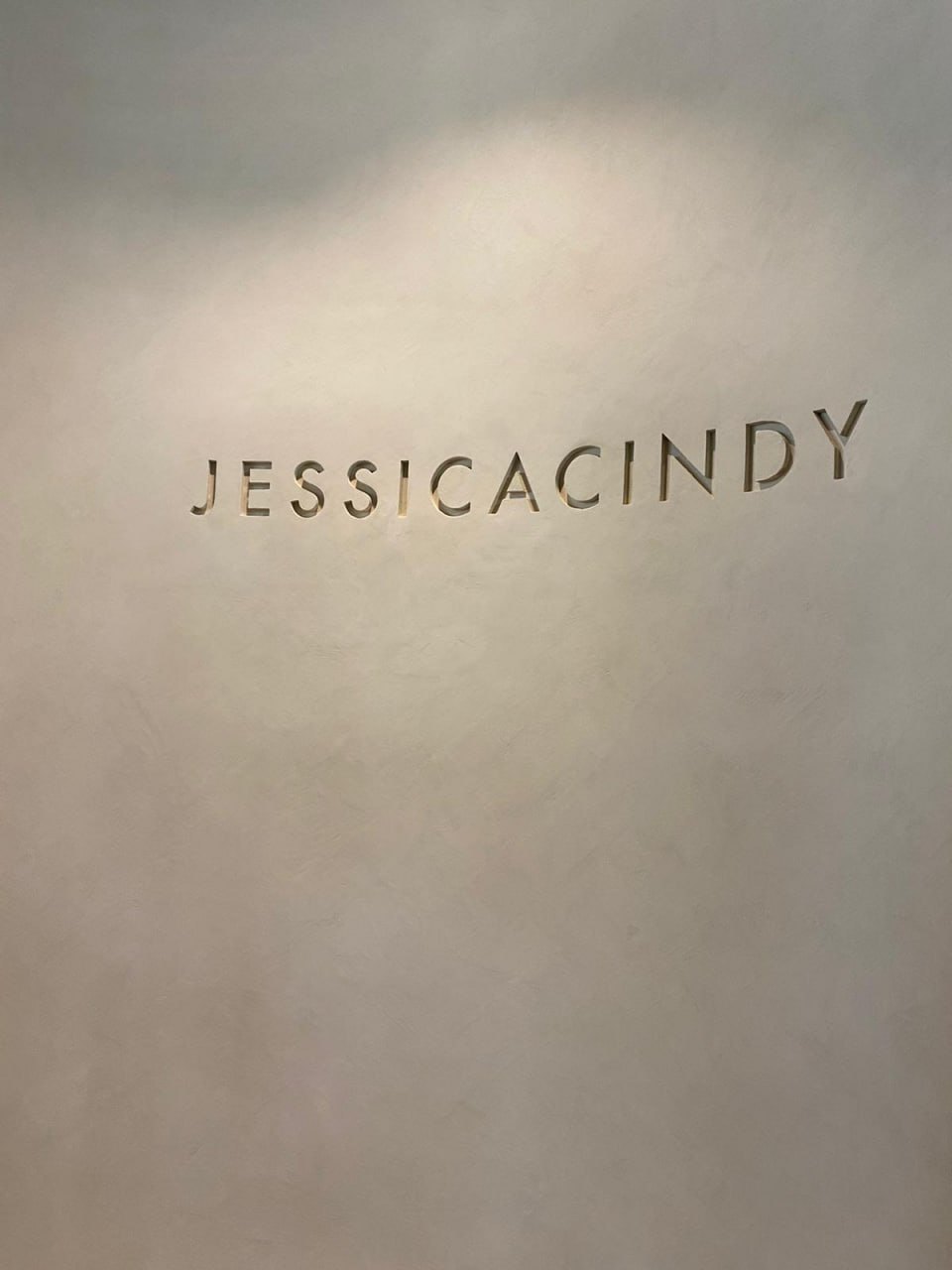 Grey limewash feature wall with the Jessica Cindy name sign